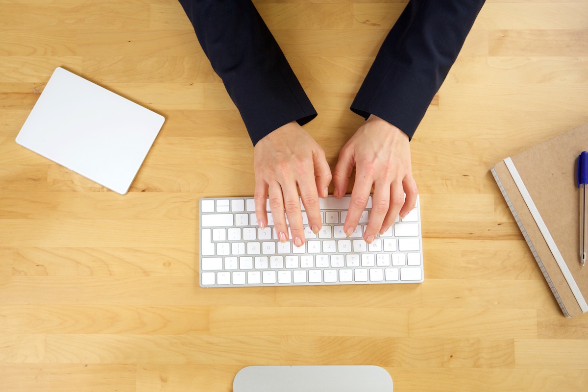 Image from above of hands typing on keyboard